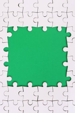 Beyaz jigsaw bulmaca yeşil alan çevresinde yapılan bir dikdörtgen şeklinde çerçeveleme