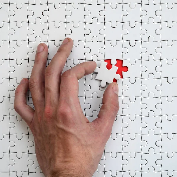 男性の手は 欠落している要素が つ組み立てられた状態で白いパズルのテクスチャ — ストック写真