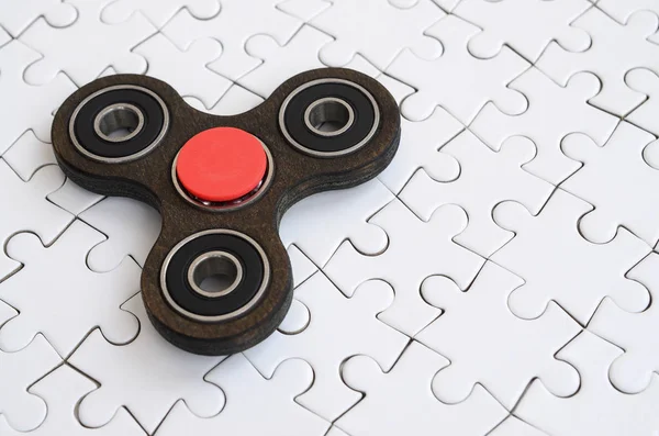 Ein Hölzerner Spinner Liegt Auf Weißem Puzzle Hintergrund — Stockfoto