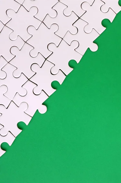 Frammento Puzzle Bianco Piegato Sullo Sfondo Una Superficie Plastica Verde — Foto Stock