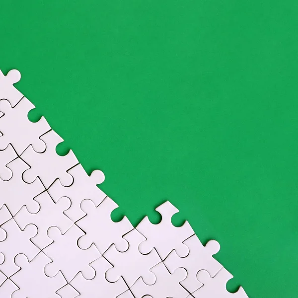 Frammento Puzzle Bianco Piegato Sullo Sfondo Una Superficie Plastica Verde — Foto Stock