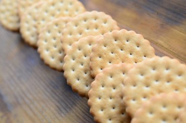 Yuvarlak sandviç kurabiye doldurma Hindistan cevizi ile büyük miktarlarda bir kahverengi ahşap yüzey üzerinde yer almaktadır. Kopya alanı ahşap bir zemin üzerine yemeklik fotoğrafı davranır