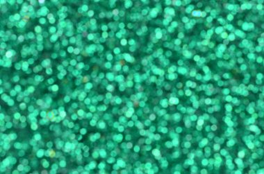 Yeşil dekoratif payetler büyük miktarda. Arka plan bulanık görüntü parlak bokeh ışıklar ışık rasgele bir sırada yansıtan küçük elemanları ile