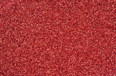 Kırmızı dekoratif payetler büyük miktarda. Arka plan doku ışık rasgele bir sırada yansıtmak, küçük parlak elemanları ile. Glitter doku