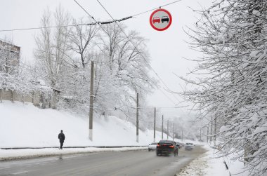 Sollama yasaktır. İşareti tüm araçlara yol bölümüne sollama yasaklar. Karla kaplı yol üzerinde asılı bir yol işareti