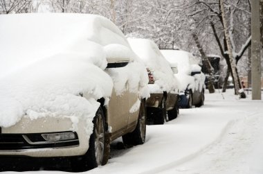 Şiddetli bir kar yağışı sonrası arabanın parçası bir kar tabakasının altında. Arabanın vücudu beyaz karla kaplı.
