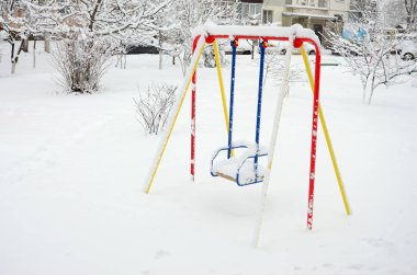 Çocuk salıncak, sonra yoğun bir kar yağışı kar kalın bir tabaka ile kaplı
