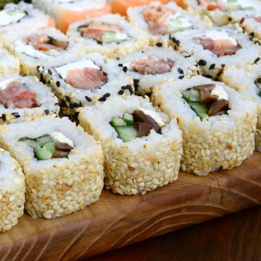 Bir sürü suşi Close-Up farklı dolguları yalanla ahşap yüzeyde alır. Bir kopya alanı ile pişmiş klasik Japon gıda makro çekim