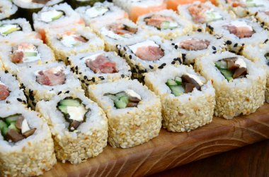 Bir sürü suşi Close-Up farklı dolguları yalanla ahşap yüzeyde alır. Bir kopya alanı ile pişmiş klasik Japon gıda makro çekim