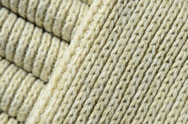 Yumuşak sarı örme kazak bileşimi. Makro doku bağlarında iplikler