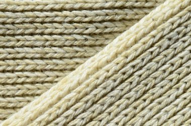 Yumuşak sarı örme kazak bileşimi. Makro doku bağlarında iplikler