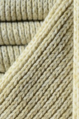 Yumuşak sarı örme kazak bileşimi. Makro doku bağlarında iplikler