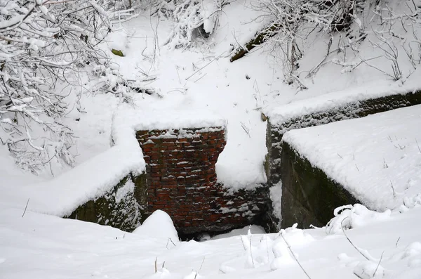 Underground bunker of old brick walls in winter after snowfall