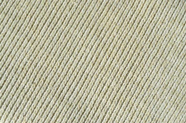 Fabric texture of a soft yellow knitted sweater. Macro image of the structure of bindings in yarns