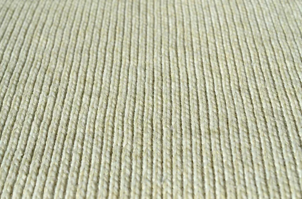 Fabric texture of a soft yellow knitted sweater. Macro image of the structure of bindings in yarns