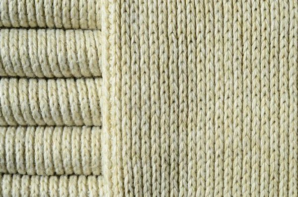 Composition of a soft yellow knitted sweater. Macro texture of bindings in yarns