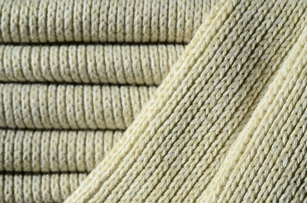 Composition of a soft yellow knitted sweater. Macro texture of bindings in yarns