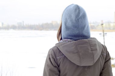 Kışın ufuk hattı Kuzey gökyüzü ve donmuş göl mesafe içine bakarak bir kahverengi ceket genç bir beyaz kız