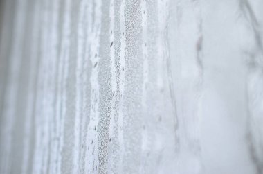 Bir sürü damla ve yoğunlaşma ile misted bir cam doku akar. Arka plan resmi