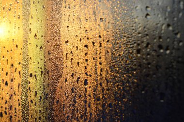 Buğulu cam damlar şafakta güneş ışığına karşı yoğunlaşma ve bir çok damla doku. Arka plan resmi