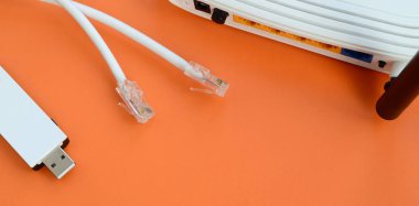 Internet yönlendiricisi, taşınabilir Usb kablosuz adaptör ve internet kablosu fiş bir parlak turuncu arka plan üzerinde yalan. Internet bağlantısı için gerekli öğeler