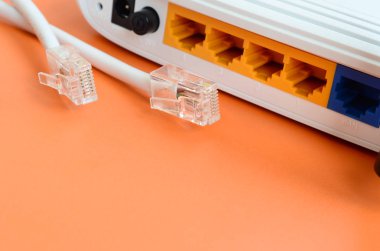 Internet yönlendirici ve Internet kablosu fiş bir parlak turuncu arka plan üzerinde yalan. Internet bağlantısı için gerekli öğeler