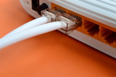 Internet kablosu fiş bir parlak turuncu arka plan üzerinde yatıyor Internet yönlendirici bağlanır. Internet bağlantısı için gerekli öğeler