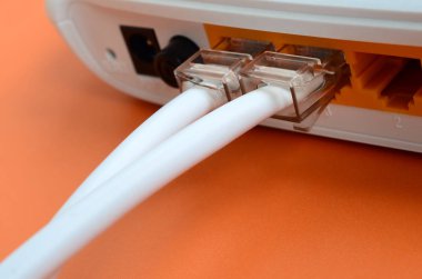 Internet kablosu fiş bir parlak turuncu arka plan üzerinde yatıyor Internet yönlendirici bağlanır. Internet bağlantısı için gerekli öğeler