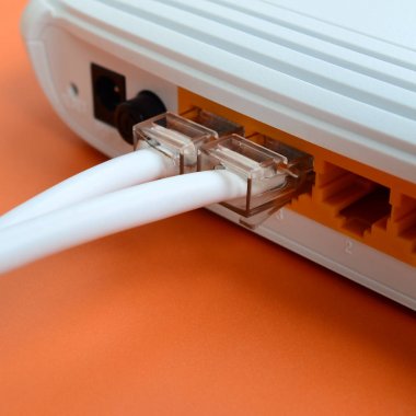 Internet kablosu fiş bir parlak turuncu arka plan üzerinde yatıyor Internet yönlendirici bağlanır. Internet bağlantısı için gerekli öğeler