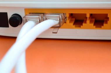 Internet kablosu fiş bir parlak turuncu arka plan üzerinde yatıyor Internet yönlendirici bağlanır. Internet bağlantısı için gerekli öğeler