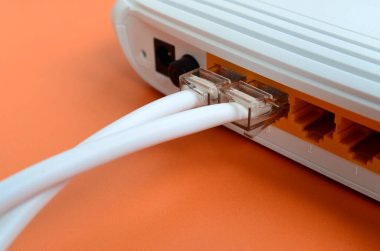 Internet kablosu fiş bir parlak turuncu arka plan üzerinde yatıyor Internet yönlendirici bağlanır. Internet bağlantısı için gerekli öğeler