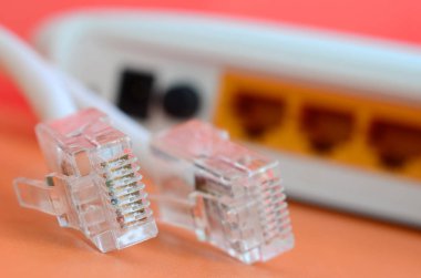 Internet yönlendirici ve Internet kablosu fiş bir parlak turuncu arka plan üzerinde yalan. Internet bağlantısı için gerekli öğeler