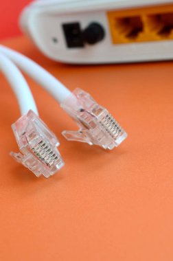 Internet yönlendirici ve Internet kablosu fiş bir parlak turuncu arka plan üzerinde yalan. Internet bağlantısı için gerekli öğeler