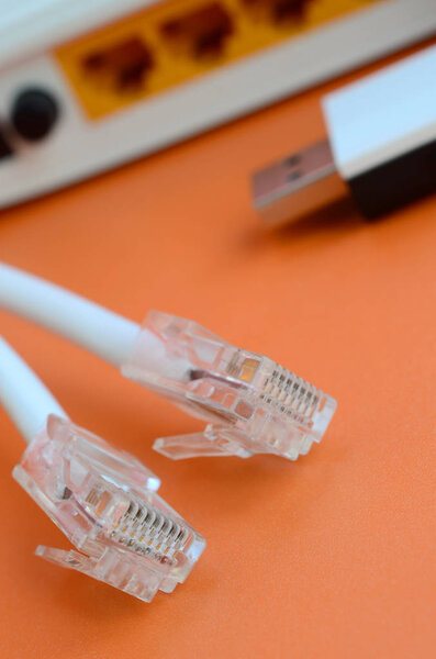 Internet router, portable USB wi-fi adapter and internet cable plugs lie on a bright orange background. Items required for internet connection