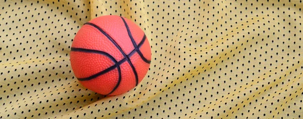 Μικρά πορτοκαλί καουτσούκ μπάσκετ βρίσκεται σε ένα κίτρινο σπορ ζέρσεϊ clo — Φωτογραφία Αρχείου