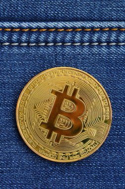 Altın Bitcoin bir kot kumaş üzerine yatıyor. Yeni sanal para. Yeni Kripto para paralar şeklinde