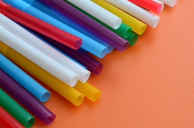 İçecekler için birçok renkli payet yatıyor bir parlak turuncu arka plana yüzeye