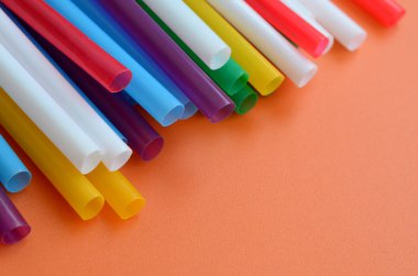 İçecekler için birçok renkli payet yatıyor bir parlak turuncu arka plana yüzeye