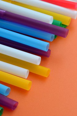 İçecekler için birçok renkli payet yatıyor bir parlak turuncu arka plana yüzeye