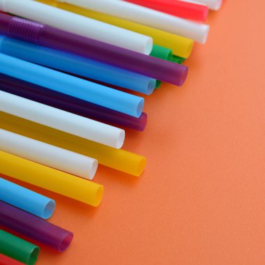 İçecekler için birçok renkli payet yatıyor bir parlak turuncu arka plana yüzeye