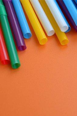 İçecekler için birçok renkli payet yatıyor bir parlak turuncu arka plana yüzeye