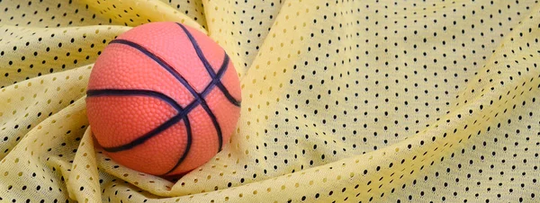 Μικρά πορτοκαλί καουτσούκ μπάσκετ βρίσκεται σε ένα κίτρινο σπορ ζέρσεϊ clo — Φωτογραφία Αρχείου