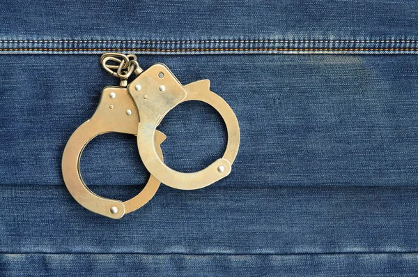 Police Steel Handcuffs Lying Dark Blue Jeans Background — Stock Photo, Image
