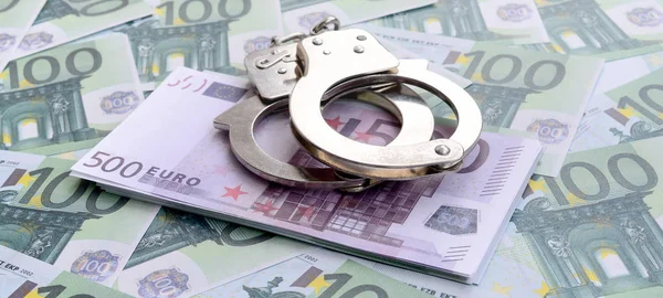 Die Handschellen der Polizei klickten auf einem grünen Geldschein im Wert von 100 Euro. Viel Geld bildet einen unendlichen Haufen — Stockbild Die Handschellen Der Polizei Klickten Auf Einem Grünen Geldschein Wert — Stockfoto
