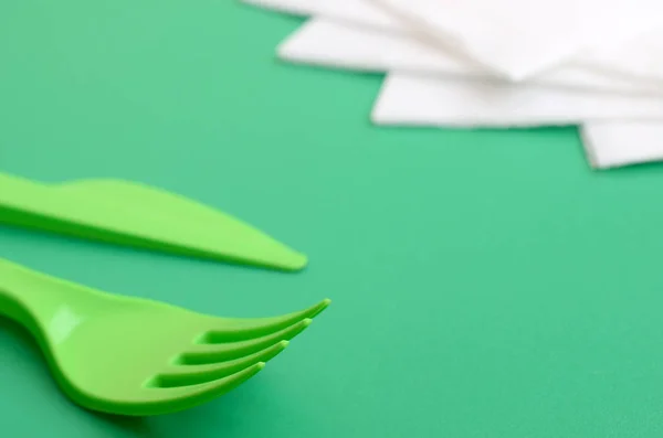 Disposable plastic cutlery green. Plastic fork and knife lie on