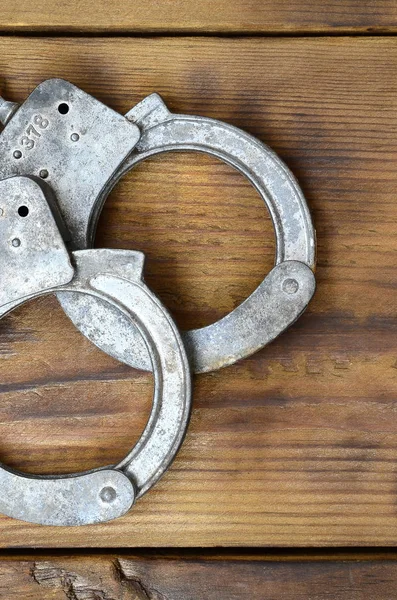 Old Rusty Police Handcuffs Lie Scratched Wooden Surface Concept Old — Stock Photo, Image