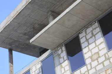 Büyük beton tuğla yapılan çok katlı binanın bitmemiş bir yapısının parçası