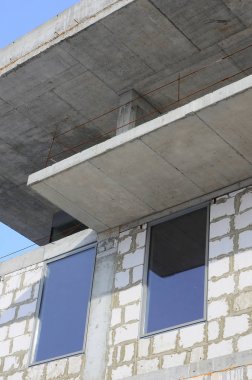 Büyük beton tuğla yapılan çok katlı binanın bitmemiş bir yapısının parçası