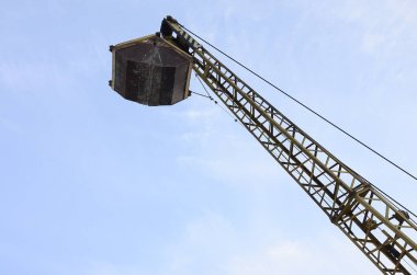 Mavi gökyüzü arka plan üzerinde eski sarı kapaklı mekanik kepçe