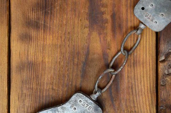 Old and rusty police handcuffs lie on a scratched wooden surface — Stock Photo, Image